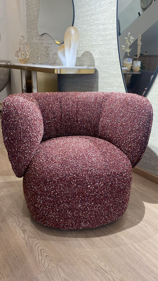 Fauteuil bergère moderne en tissu bouclé rouge rubis avec dossier arrondi et assise confortable, idéal pour un salon contemporain et élégant.