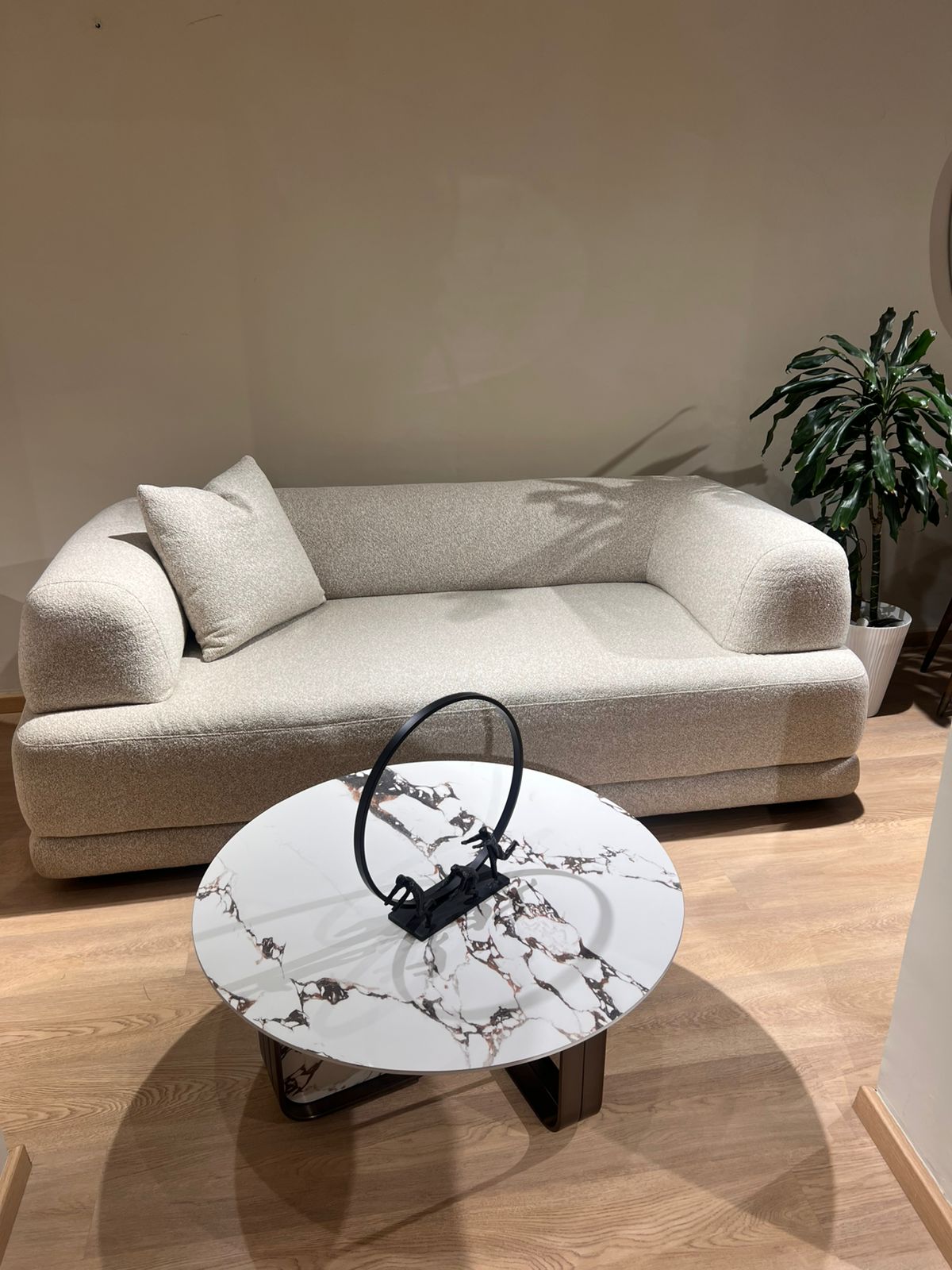 Canapé design moderne en tissu bouclé beige, aux formes arrondies et minimalistes