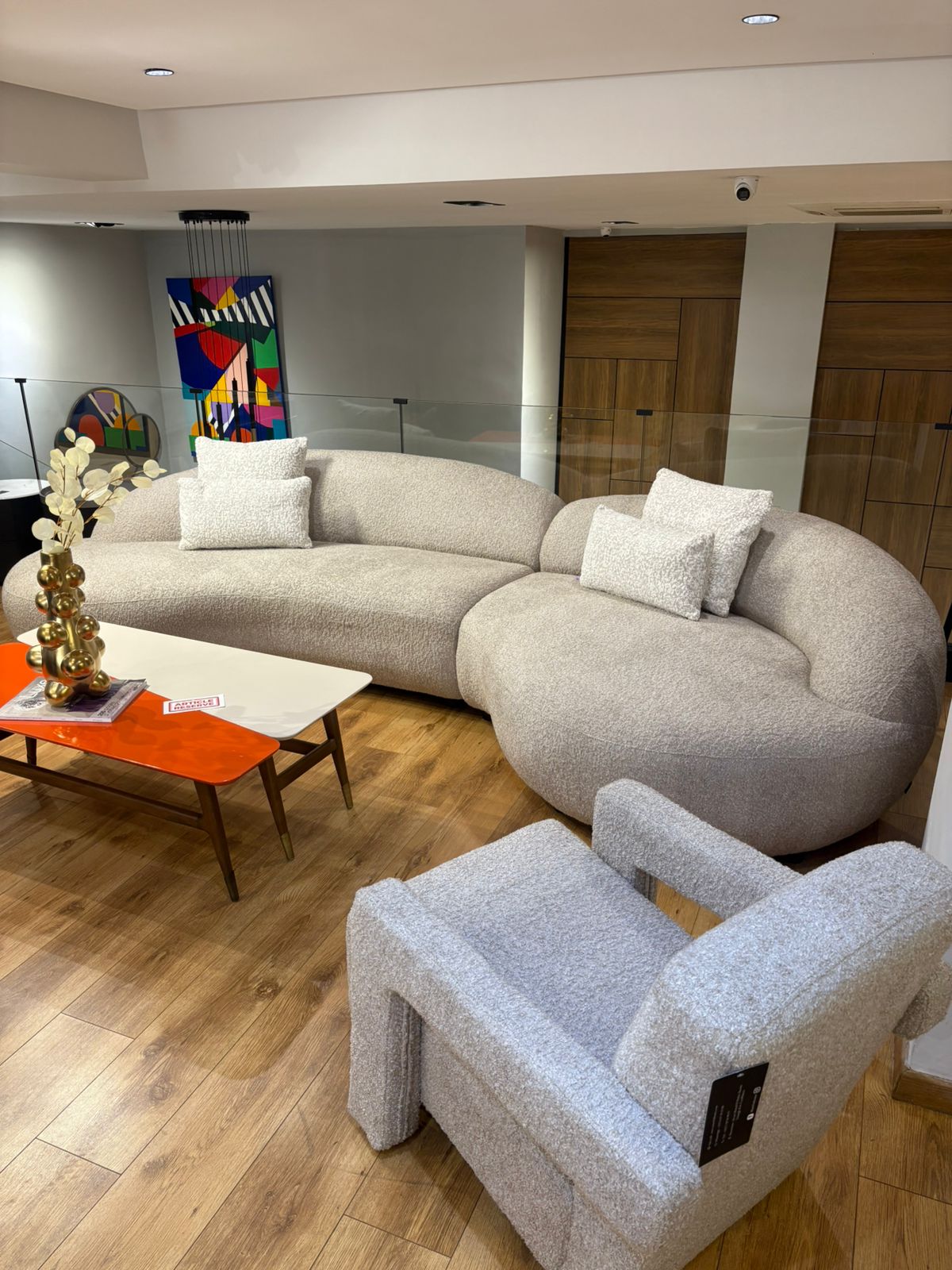 Canapé design arrondi en tissu beige avec fauteuils assortis dans un salon moderne lumineux