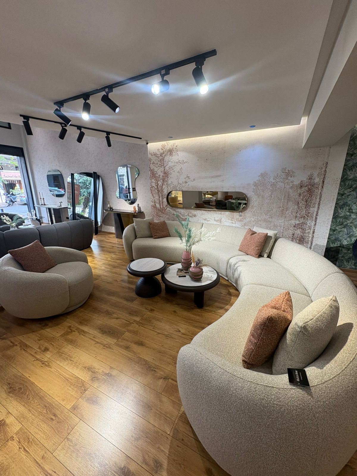 Canapé moderne courbé modulable en tissu beige avec coussins décoratifs dans un salon contemporain