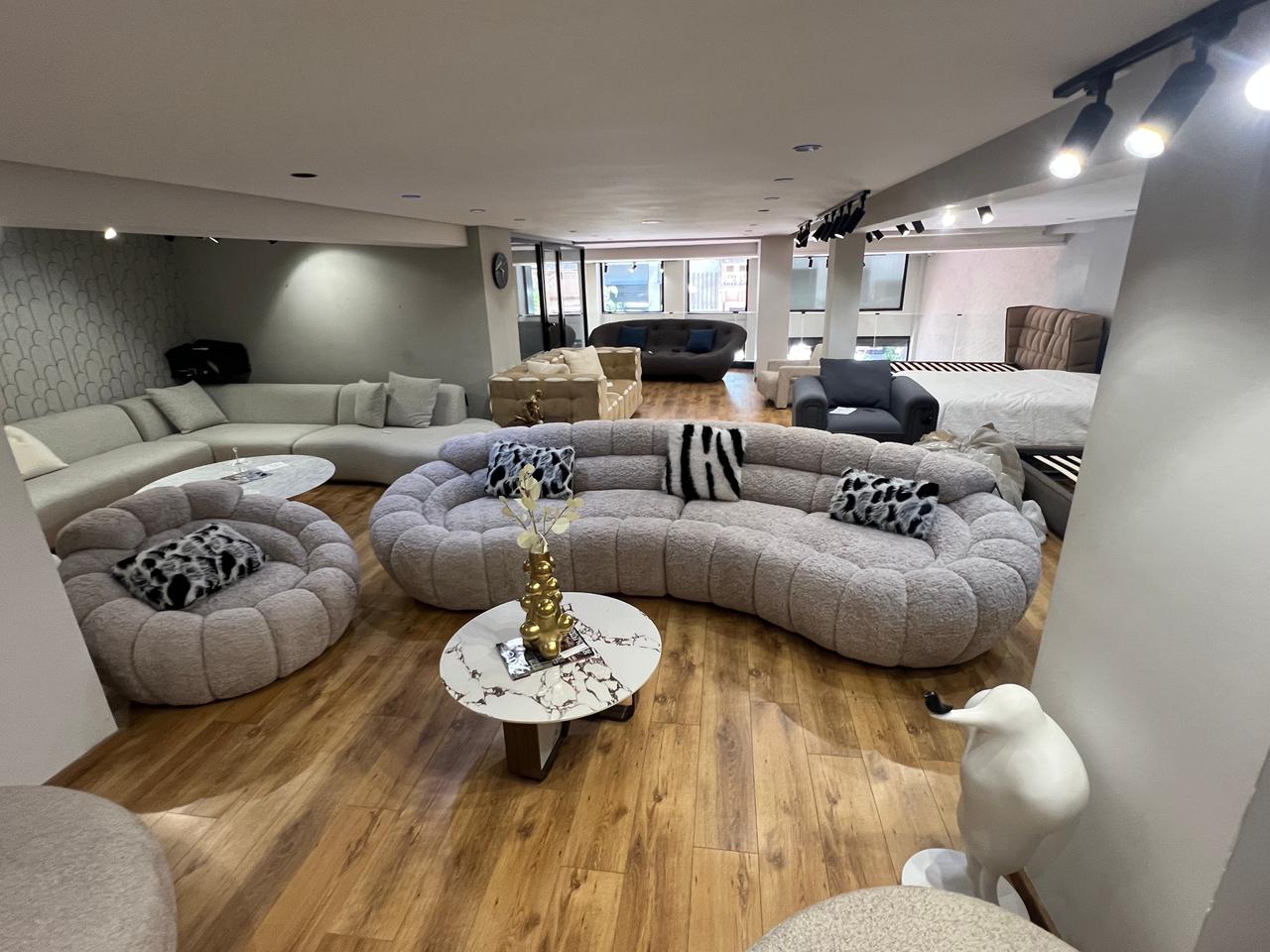 Canapé design organique en tissu bouclé beige avec formes arrondies et assise profonde pour salon moderne.