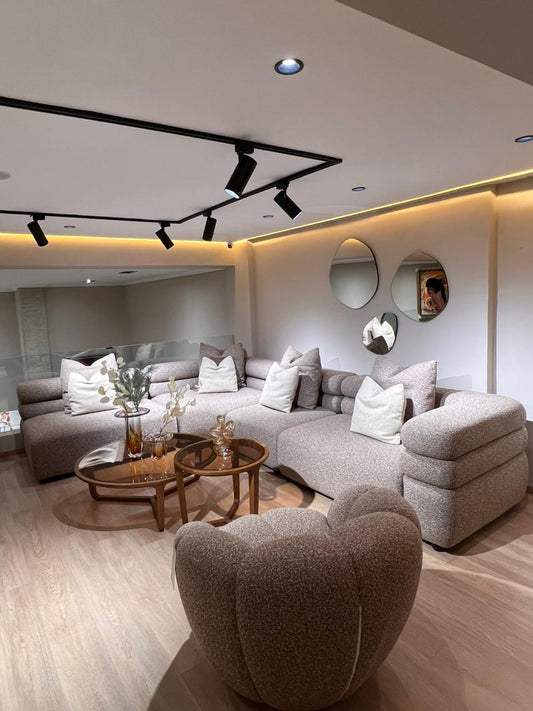 Canapé modulable beige en tissu texturé, avec assises profondes et coussins moelleux, dans un salon moderne et élégant