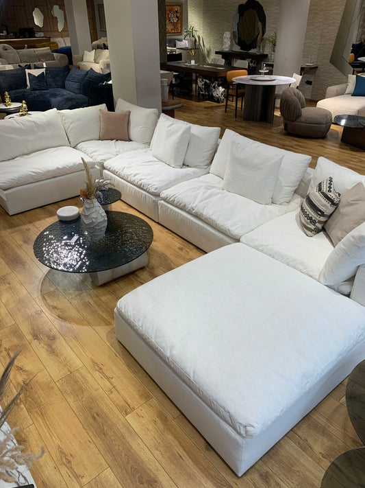  Salon moderne avec un canapé d’angle blanc spacieux, modulable et doté de coussins moelleux pour un confort optimal. 