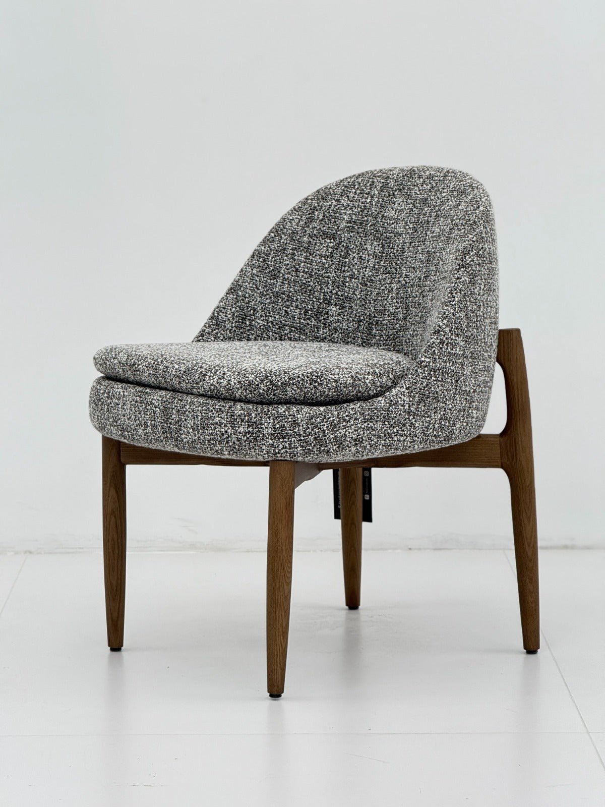 Chaise lounge contemporaine avec assise rembourrée, dossier arrondi et structure en bois, idéale pour un intérieur élégant.