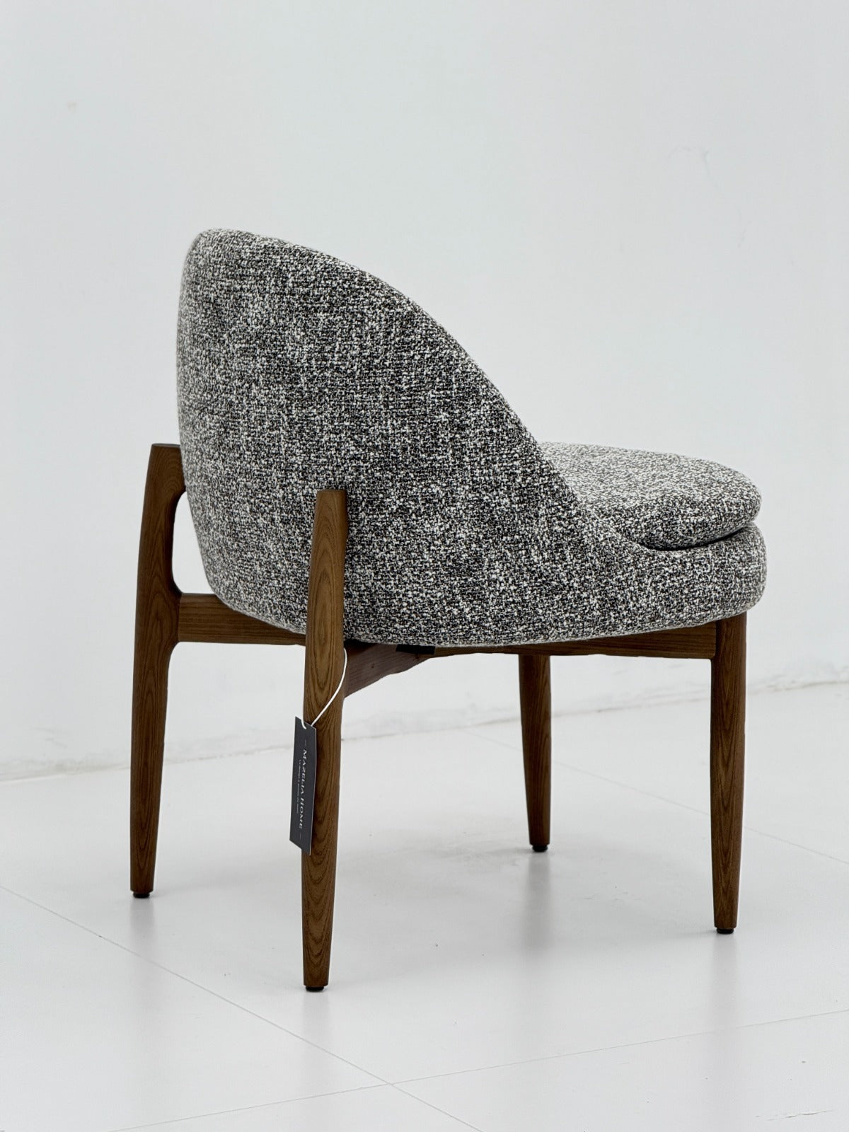 Chaise lounge contemporaine avec assise rembourrée, dossier arrondi et structure en bois, idéale pour un intérieur élégant.