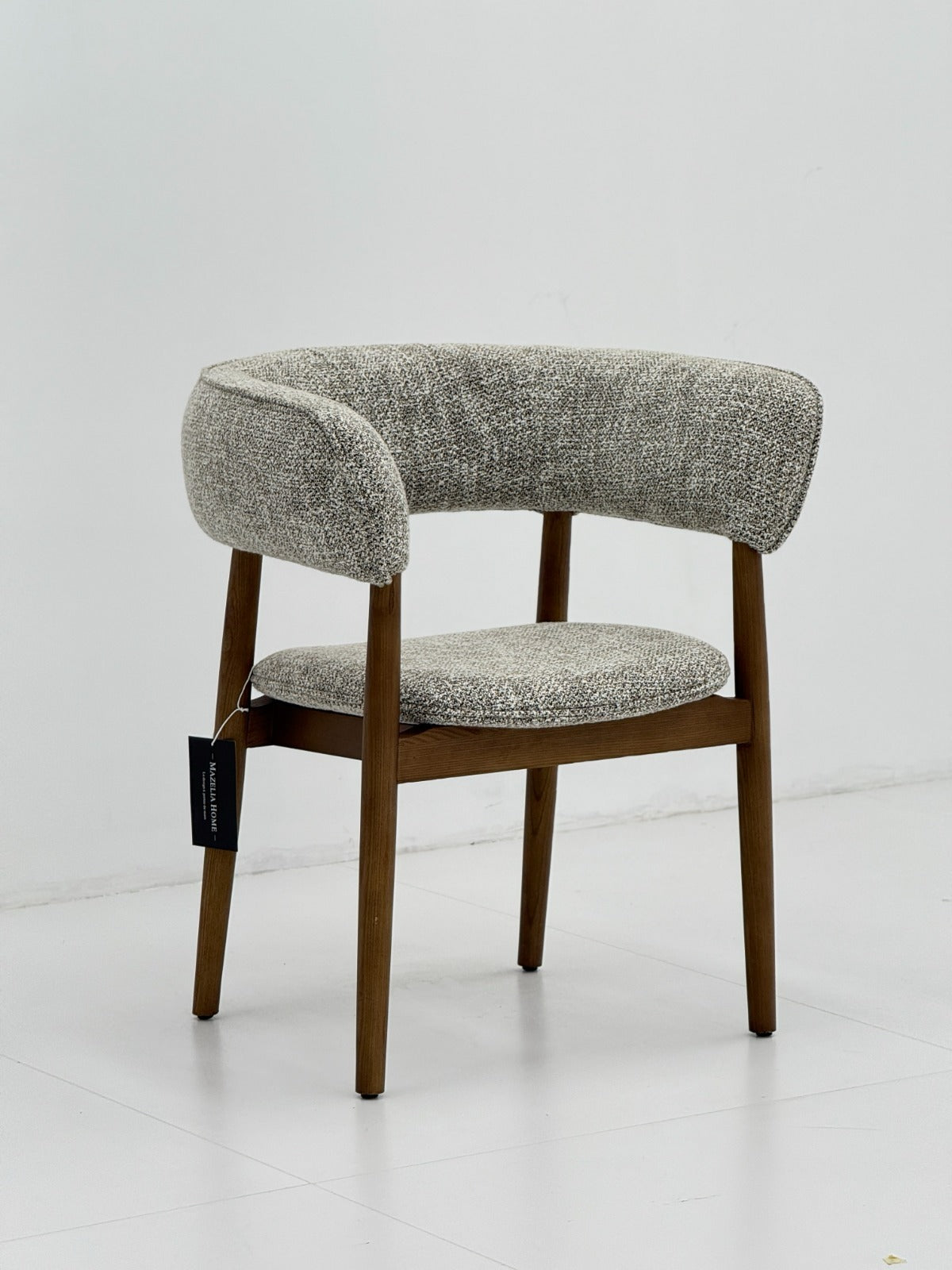 Chaise design contemporain avec dossier arrondi, assise rembourrée et structure en bois, idéale pour une salle à manger élégante.
