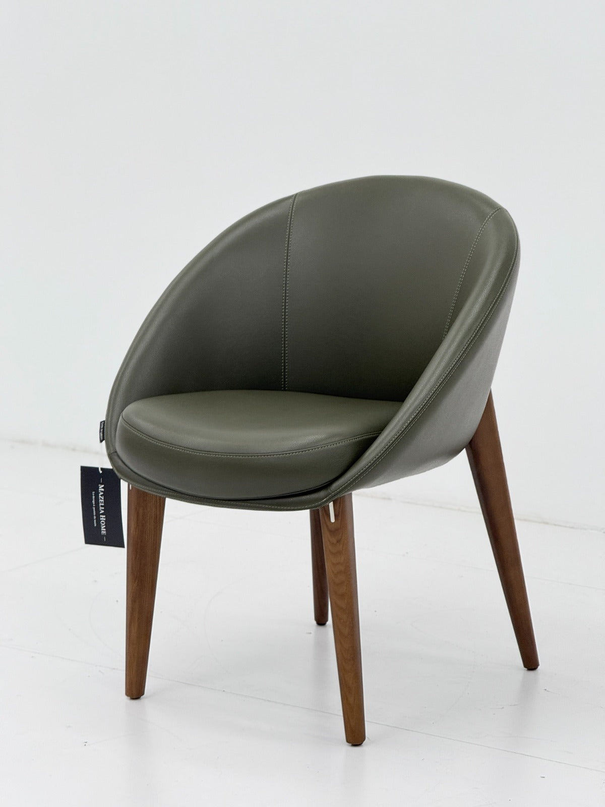Chaise moderne vert olive en similicuir avec pieds en bois massif, design enveloppant et assise confortable pour salle à manger ou bureau.
