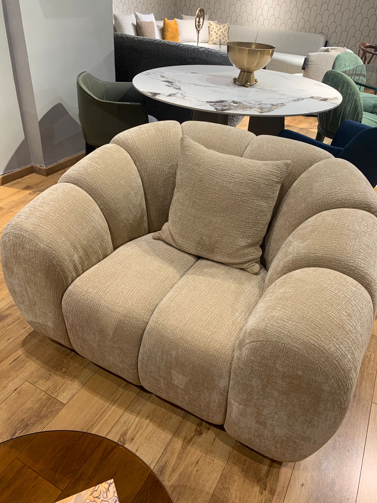 Salon élégant avec canapé trois places et fauteuil aux formes douces et arrondies