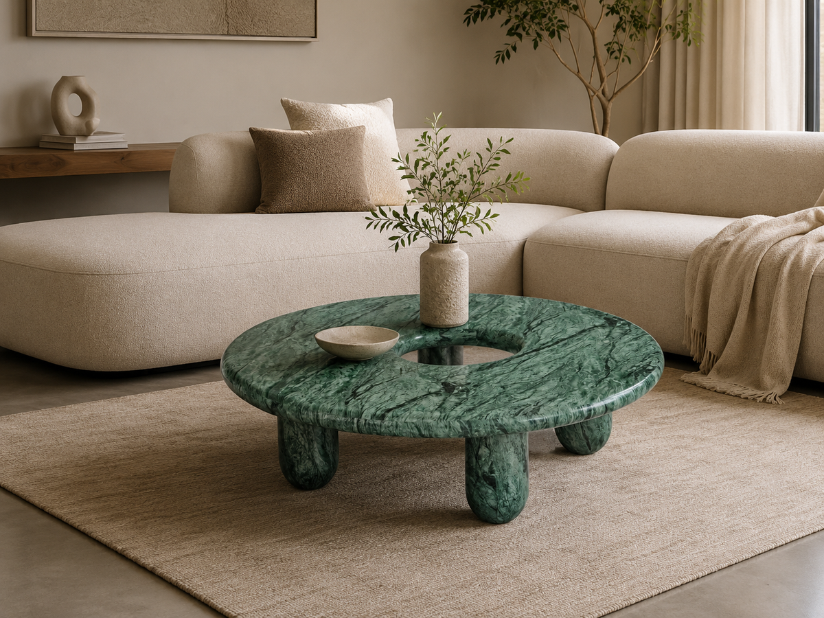 Table basse Nevada en pierre naturelle avec plateau circulaire et ouverture centrale, design contemporain et pieds arrondis.