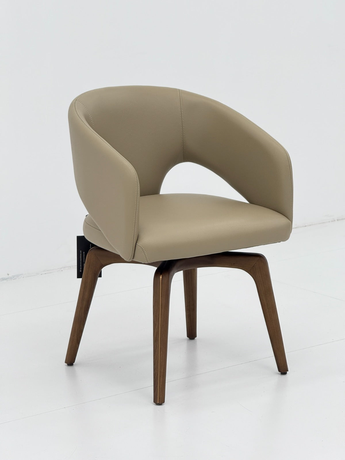 Chaise contemporaine avec assise rembourrée, dossier enveloppant et piètement en bois, idéale pour une salle à manger moderne.