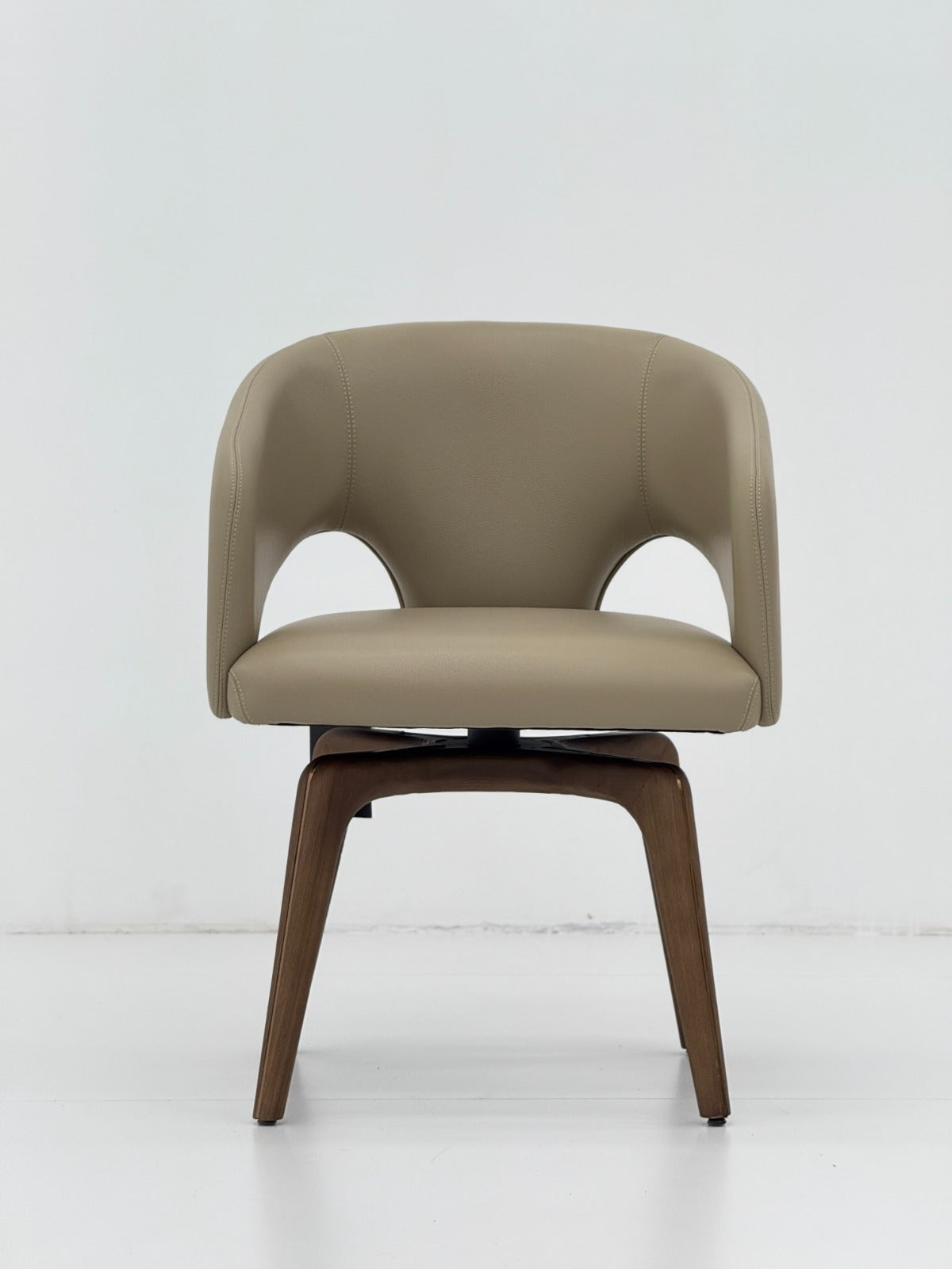 Chaise contemporaine avec assise rembourrée, dossier enveloppant et piètement en bois, idéale pour une salle à manger moderne.